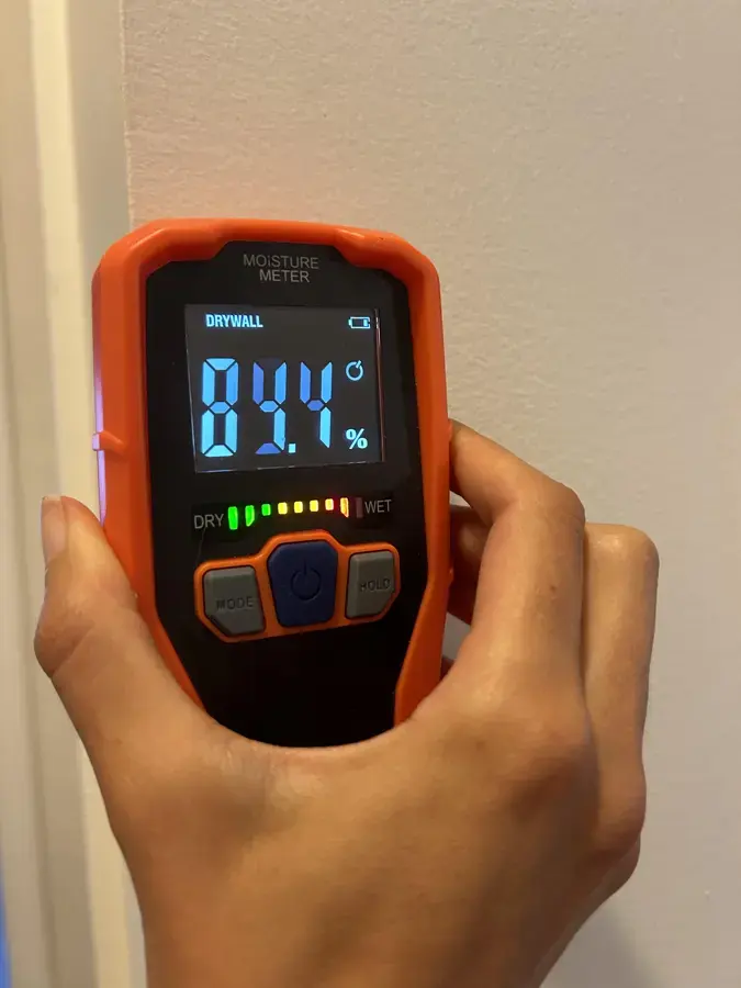 Pinless moisture meter reading a wall during water damage drying in South Gate
