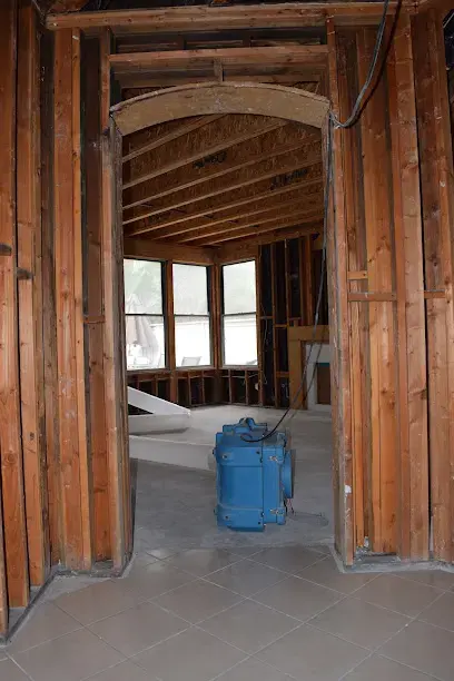 Opened framing and a dehumidifier drying a room in South Gate